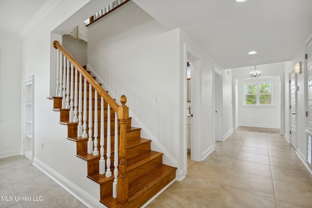 tiled foyer entrance featuring crown molding and a chandelier