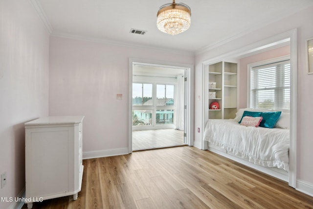 unfurnished bedroom featuring multiple windows, ornamental molding, a notable chandelier, and light hardwood / wood-style flooring