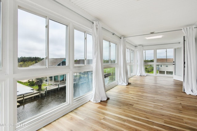 unfurnished sunroom featuring a water view