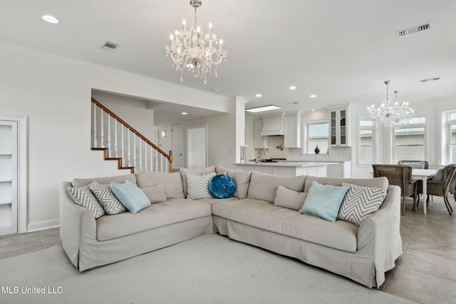 living room with a healthy amount of sunlight, ornamental molding, and a chandelier