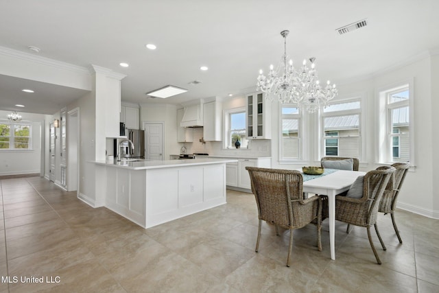 dining room featuring crown molding, sink, a notable chandelier, and a wealth of natural light