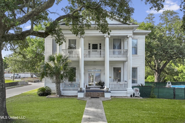 greek revival inspired property featuring a balcony and a porch