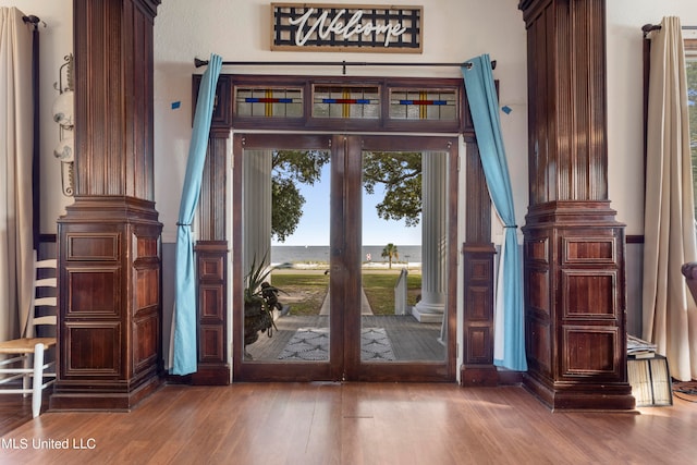 entryway featuring french doors, hardwood / wood-style flooring, and ornate columns