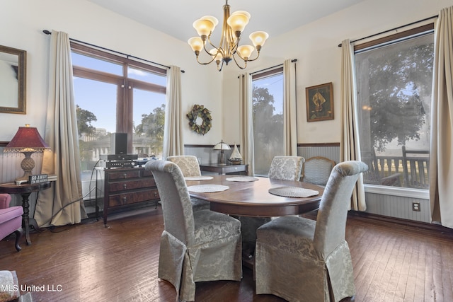 dining room with a chandelier, healthy amount of natural light, hardwood / wood-style floors, and wainscoting
