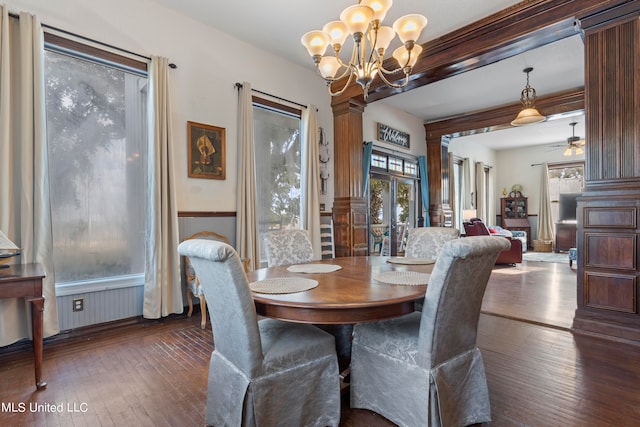 dining space with ceiling fan with notable chandelier, decorative columns, ornamental molding, and dark hardwood / wood-style floors