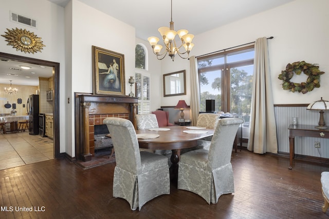 dining room featuring a chandelier, wood-type flooring, and a fireplace