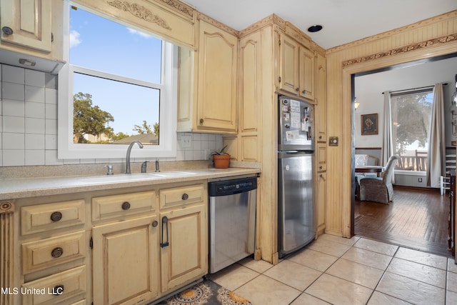 kitchen featuring decorative backsplash, light brown cabinetry, light hardwood / wood-style flooring, sink, and stainless steel appliances