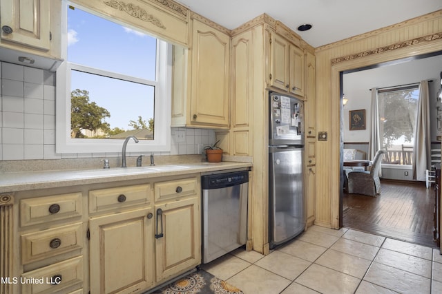 kitchen with stainless steel appliances, a sink, light countertops, and healthy amount of natural light