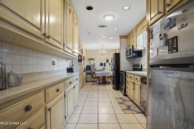 kitchen with stainless steel appliances, light countertops, backsplash, a chandelier, and light tile patterned flooring