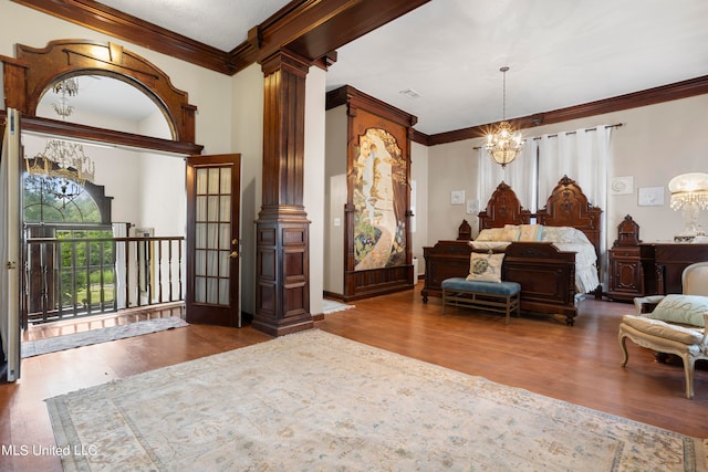 bedroom with hardwood / wood-style flooring, decorative columns, ornamental molding, and a chandelier