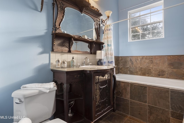 full bath with tiled tub, toilet, vanity, a shower with curtain, and backsplash