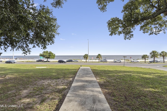 view of green lawn with a water view