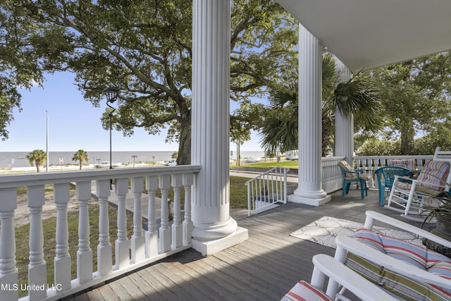 wooden deck featuring covered porch and a water view