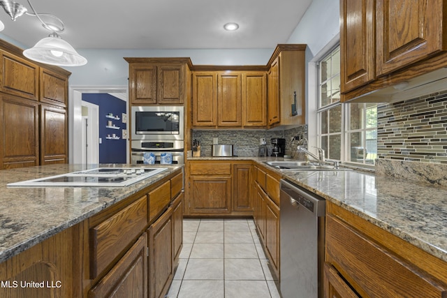 12880 Coles Cv, Gulfport, MS 39503 - kitchen featuring stainless steel appliances, brown cabinets, decorative backsplash, and light tile patterned floors