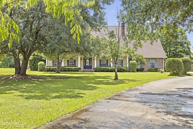 12880 Coles Cv, Gulfport, MS 39503 - view of property hidden behind natural elements featuring a front lawn, a chimney, and roof with shingles
