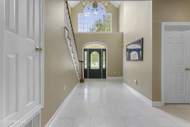 12880 Coles Cv, Gulfport, MS 39503 - foyer featuring a chandelier, stairway, a high ceiling, baseboards, and light tile patterned floors