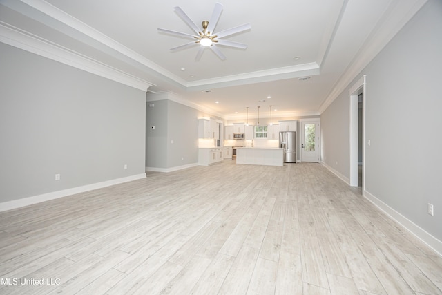 unfurnished living room with light hardwood / wood-style flooring, ornamental molding, a tray ceiling, and ceiling fan