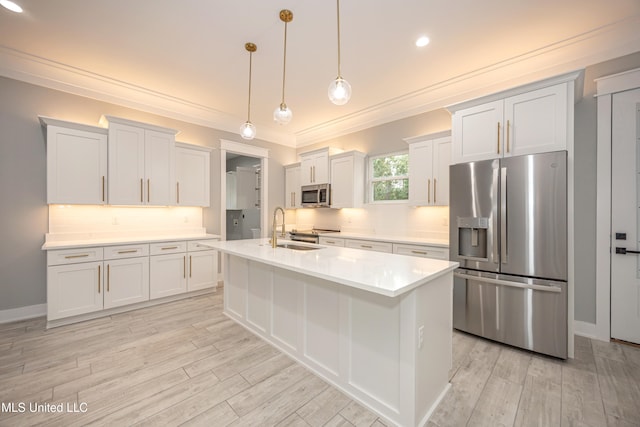 kitchen featuring white cabinets, hanging light fixtures, an island with sink, sink, and stainless steel appliances