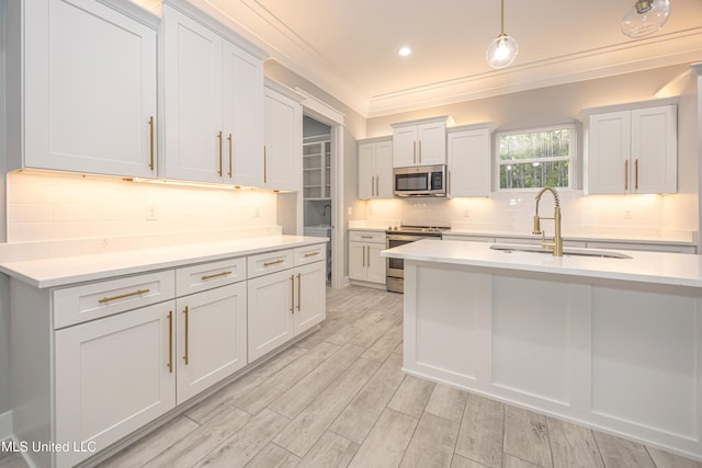 kitchen with appliances with stainless steel finishes, sink, light wood-type flooring, backsplash, and crown molding