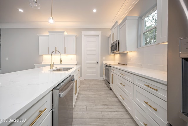 kitchen with white cabinets, appliances with stainless steel finishes, sink, and hanging light fixtures