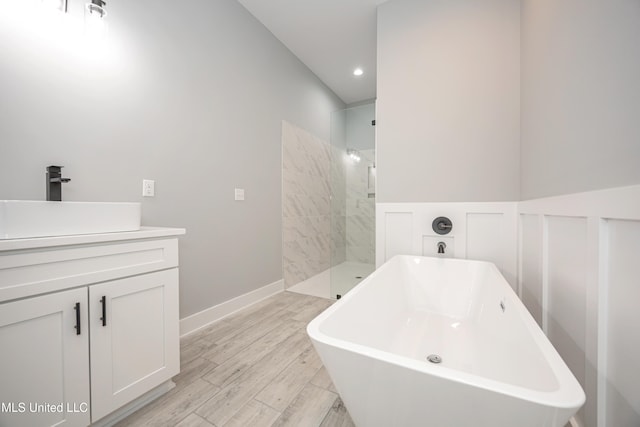 bathroom with vanity, hardwood / wood-style flooring, and plus walk in shower