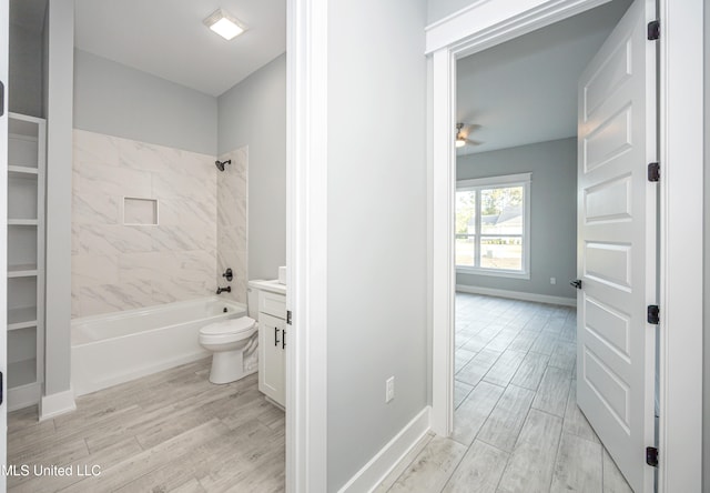 full bathroom with toilet, hardwood / wood-style floors, tiled shower / bath combo, vanity, and ceiling fan