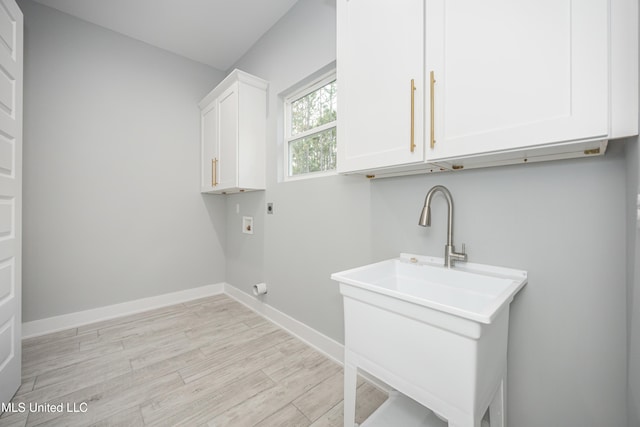 laundry room featuring sink, cabinets, electric dryer hookup, washer hookup, and light hardwood / wood-style flooring