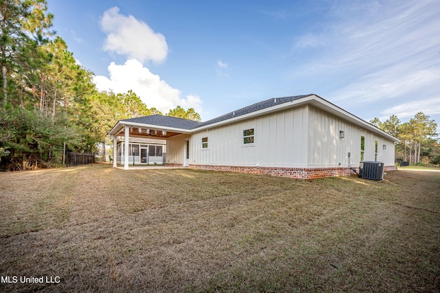 back of property with a yard, cooling unit, and a patio