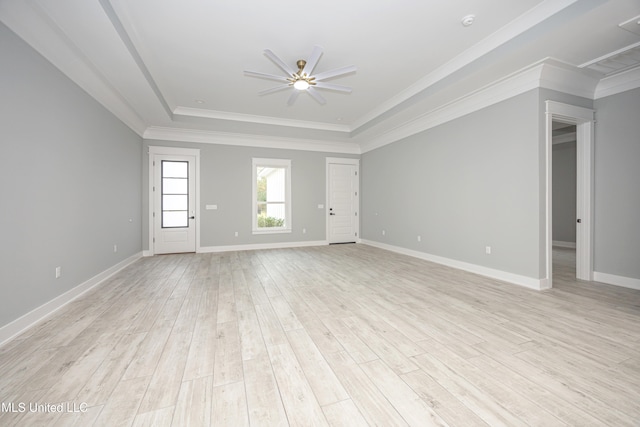 empty room with light hardwood / wood-style floors, crown molding, a raised ceiling, and ceiling fan