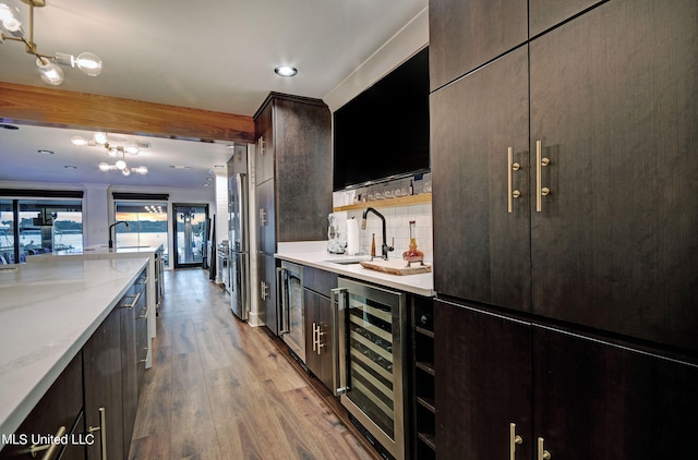 kitchen with light hardwood / wood-style floors, dark brown cabinets, sink, and beverage cooler