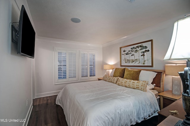 bedroom featuring crown molding and dark hardwood / wood-style floors