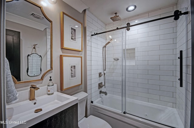 full bathroom featuring vanity, toilet, and shower / bath combination with glass door