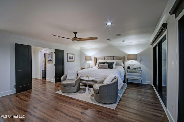 bedroom with crown molding, dark hardwood / wood-style floors, a barn door, and ceiling fan