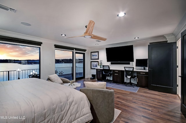 bedroom featuring access to outside, built in desk, hardwood / wood-style floors, a water view, and ceiling fan