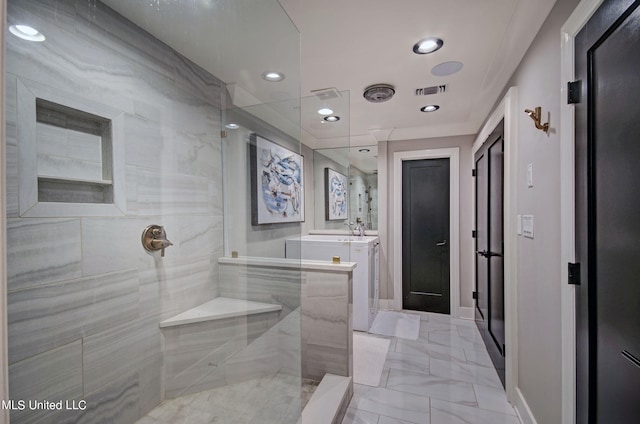 bathroom featuring a tile shower and vanity