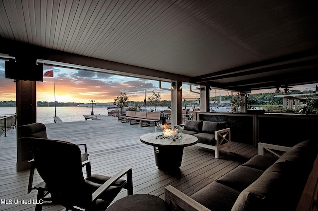 deck at dusk with a water view and outdoor lounge area