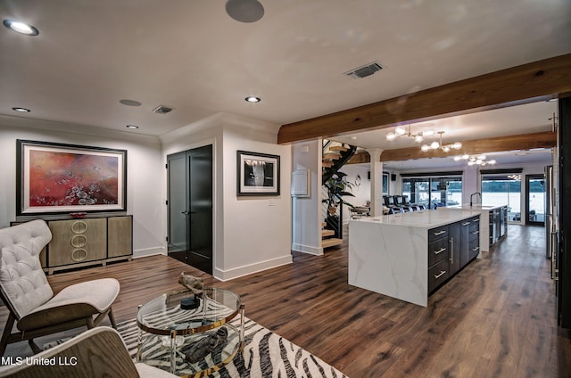 interior space featuring an inviting chandelier, dark hardwood / wood-style floors, beam ceiling, and decorative light fixtures