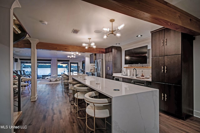 kitchen with tasteful backsplash, a kitchen island, dark brown cabinets, dark hardwood / wood-style flooring, and stainless steel refrigerator with ice dispenser