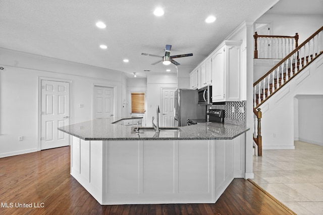 7906 Kirkwood Cv, Olive Branch, MS 38654 - kitchen featuring stainless steel appliances, dark stone counters, a ceiling fan, recessed lighting, and white cabinetry