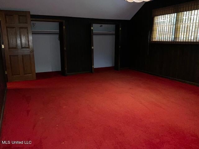 unfurnished bedroom featuring vaulted ceiling and carpet flooring