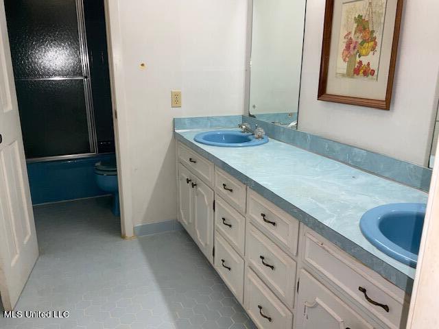 bathroom featuring tile patterned flooring, vanity, and toilet