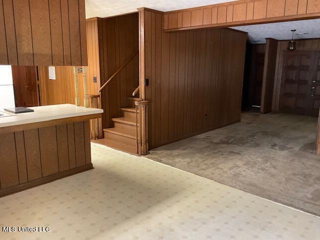 interior space featuring light colored carpet, radiator heating unit, and wooden walls