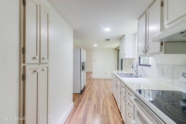 6910 Apuwai Pl, Diamondhead, MS 39525 - kitchen featuring stove, white fridge with ice dispenser, white cabinets, light wood finished floors, and under cabinet range hood