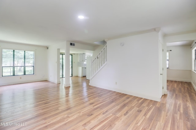 6910 Apuwai Pl, Diamondhead, MS 39525 - unfurnished living room with light wood-type flooring and stairway