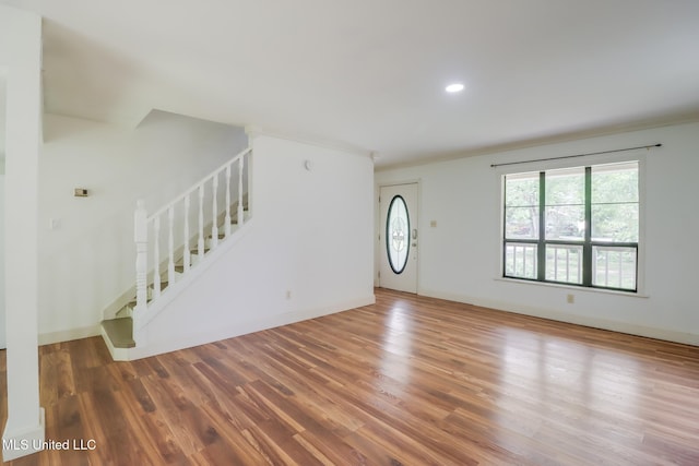 6910 Apuwai Pl, Diamondhead, MS 39525 - unfurnished living room featuring stairs, wood finished floors, ornamental molding, and recessed lighting