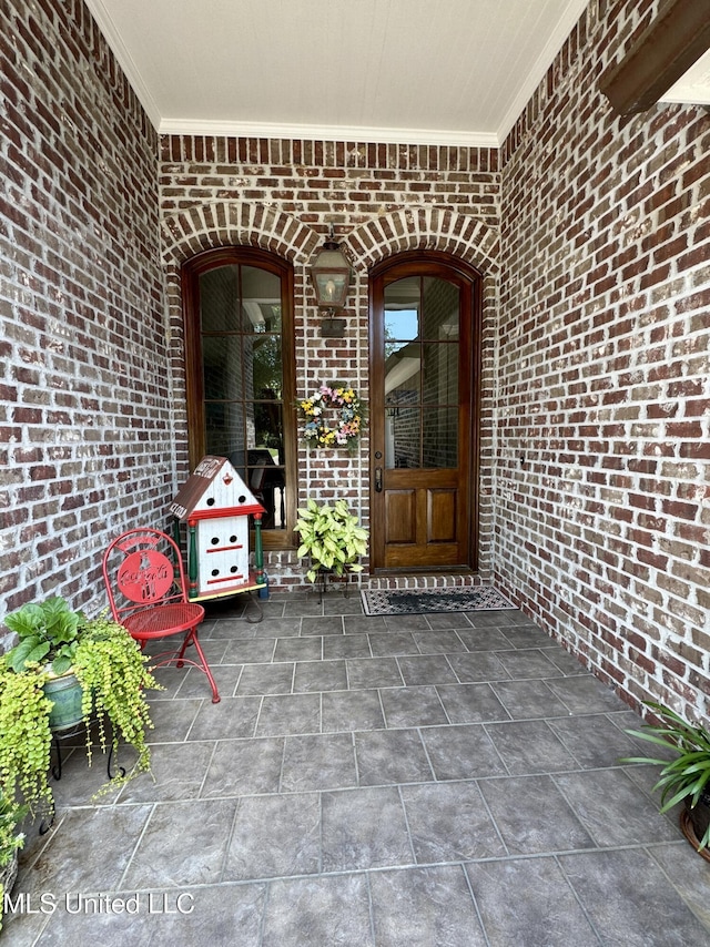 property entrance featuring brick siding
