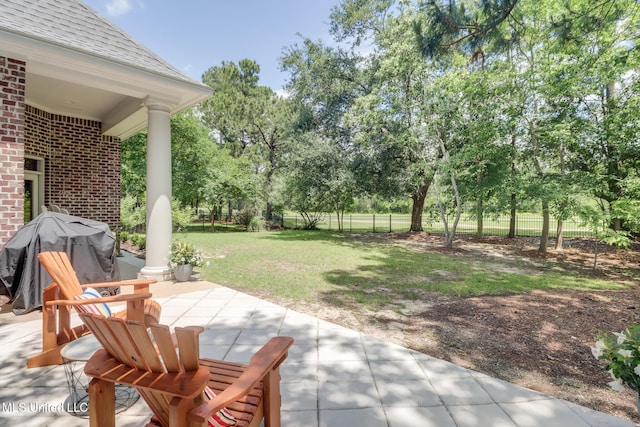 view of patio / terrace with view of scattered trees and a grill