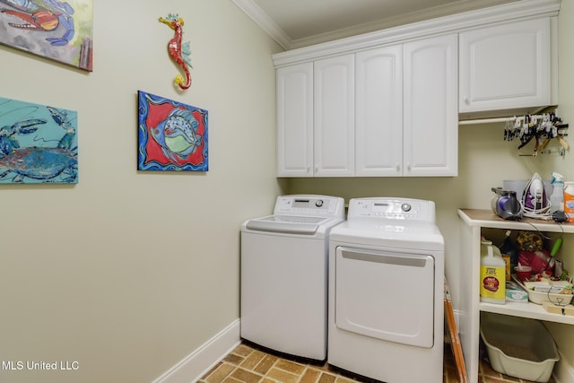 washroom featuring baseboards, cabinet space, washing machine and clothes dryer, brick patterned flooring, and crown molding