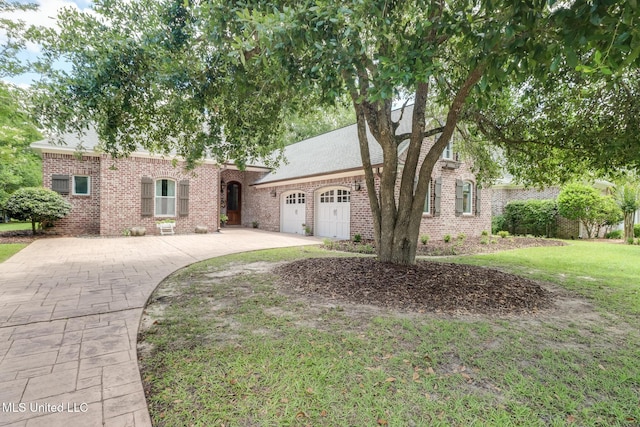 view of front of home featuring a garage, brick siding, concrete driveway, and a front yard