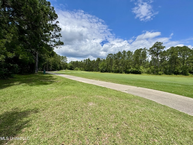 view of property's community with a yard and a wooded view